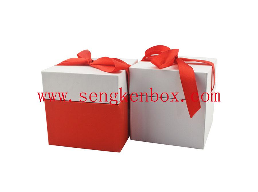 Caja de regalo de papel con lazo rojo